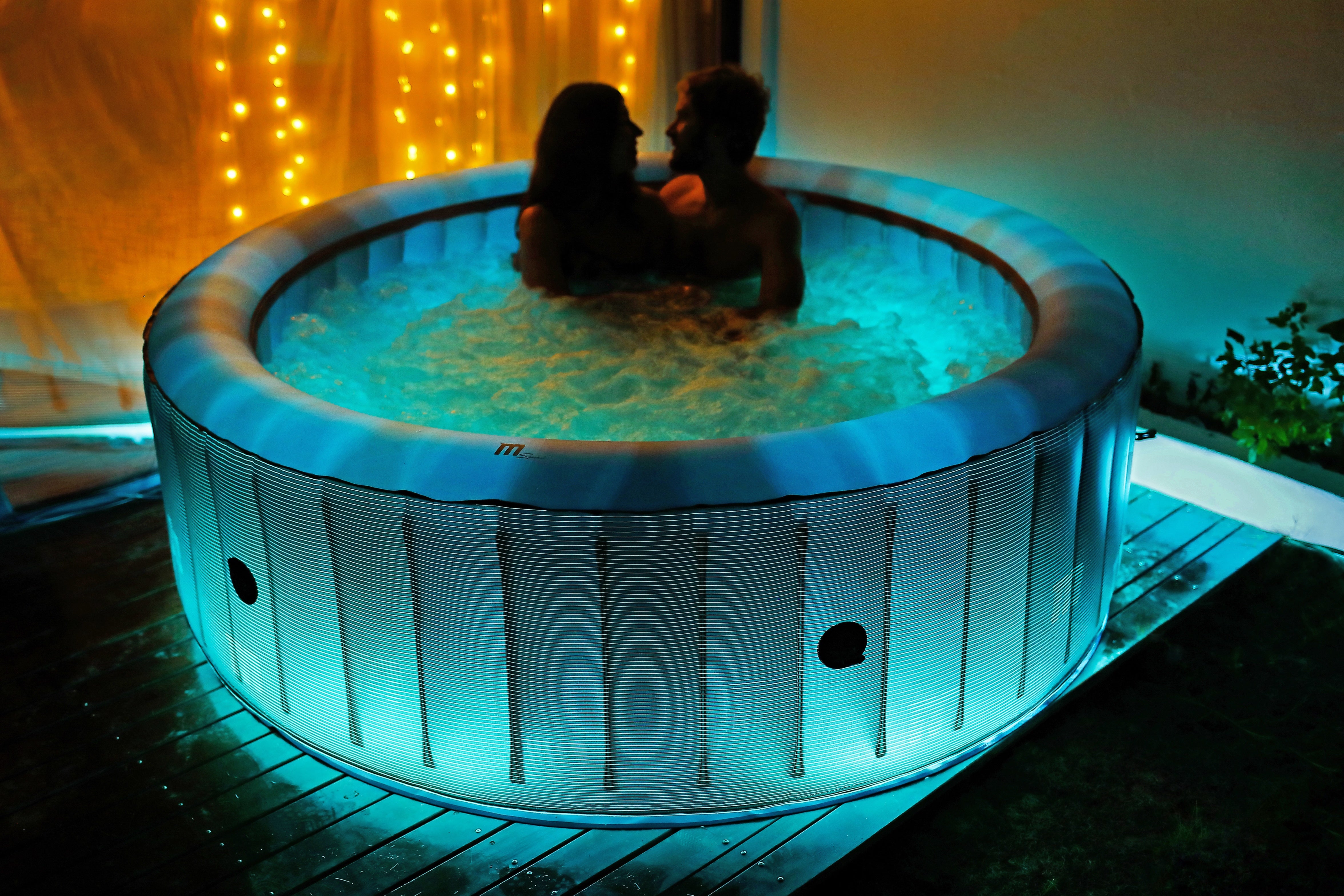 In der Nacht relaxt ein junges Pärchen im beleuchteten - Sanotechnik Aufblasbaren MSpa Whirlpool STARRY